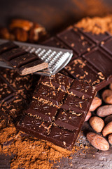 Chocolate products. Chocolate, cocoa beans, cocoa and nuts on wooden background. 