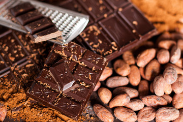 Chocolate products. Chocolate, cocoa beans, cocoa and nuts on wooden background. 