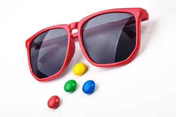 Red sunglasses and many colorful round candys.