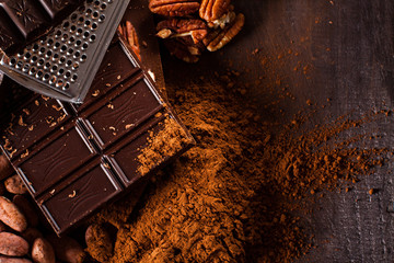 Chocolate products. Chocolate, cocoa beans, cocoa and nuts on wooden background. 