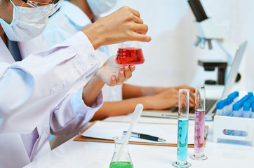 two scientists experimenting and analysing with chemicals in laboratory
