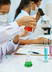 portrait of scientists experimenting and analysing with chemicals in laboratory

