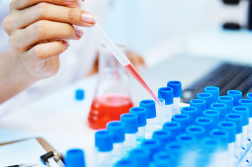 close up of scientists experimenting and testing chemicals in laboratory
