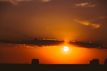 Naklejka premium Summer Field Meadow With Hay Bales Silhouettes, Sunset, Sunris