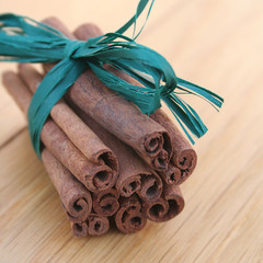 bastoncini di cannella legati da nastro su tavolo di legno © saratm
