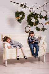 Naklejka premium Concept of christmas holiday / Handsome boy and cute small girl on Christmas background