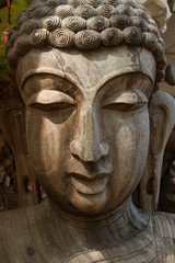 Wooden face. Face of Buddha. Face carved out of wood.
