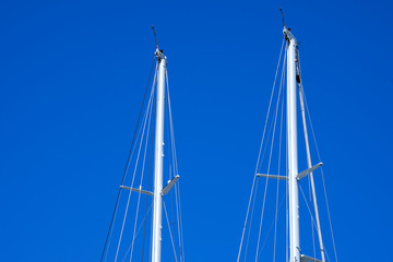 Masts of Sailboats Against a Blue Sky / Detail of two masts of sailboats against a blue clear sky