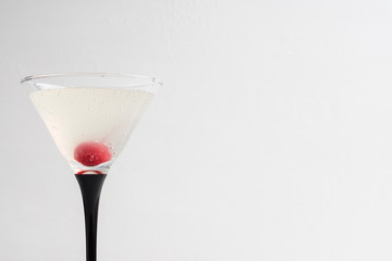 Cocktail in martini glass on the white wooden background