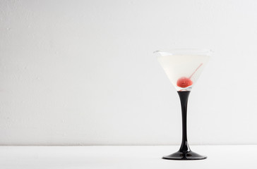 Cocktail in martini glass on the white wooden background