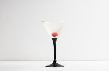 Cocktail in martini glass on the white wooden background