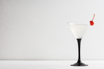 Cocktail in martini glass on the white wooden background