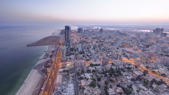 Cityscape of Ajman from rooftop night to day timelapse. Ajman is the capital of the emirate of Ajman in the United Arab Emirates