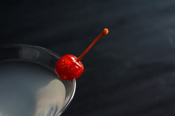 Cocktail in martini glass on the black wooden background