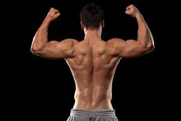 Fototapeta na wymiar Muscular male torso from behind on a black background
