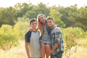 Guys holding a girl in the arms in the forest outdoors