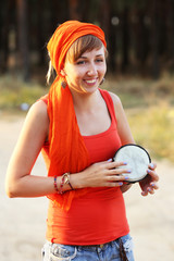 Bright smiling girl with jembe in the forest outdoors