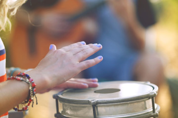 Females hands play a drum, close up