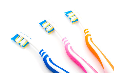 three colored toothbrushes