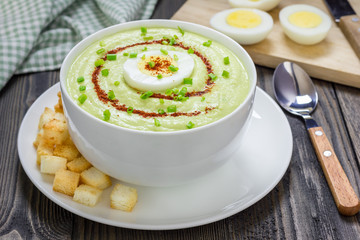 Cream soup with avocado, garnished with egg and croutons. Healthy eating.