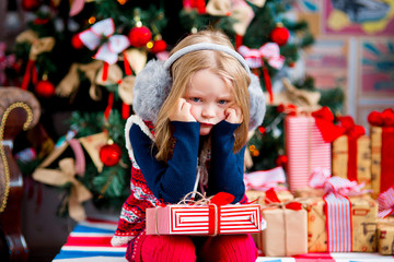 Obraz na płótnie Canvas the girl near a Christmas fir-tree in red tones