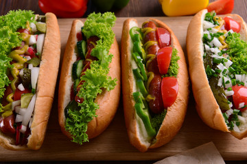 Hot dogs and vegetables on wooden cutting board