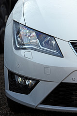  Car Headlights.White vehicle front part close up of headlights and grille.