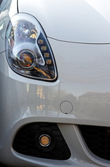 Car Headlights.White vehicle front part close up of headlights and grille.