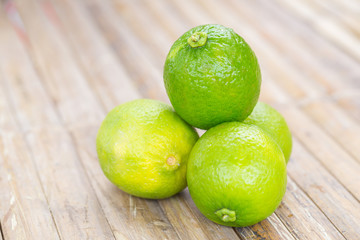 green lemons on bamboo background