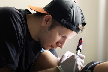 Tattooist makes tattoo, close up