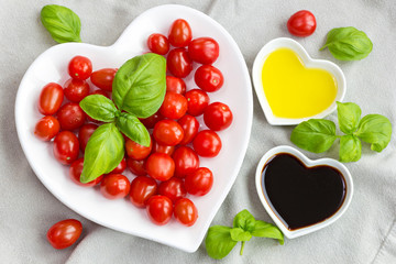 Snack tomatoes, basil, oil and vinegar to make a healthy salad