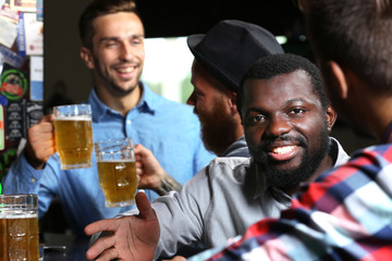Young men drinking beer in pub
