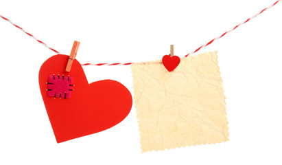 Paper hearts and empty sheet hang on cord isolated on white background
