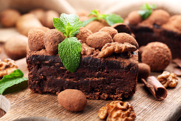 A piece of chocolate cake with walnut and mint on the table, close-up