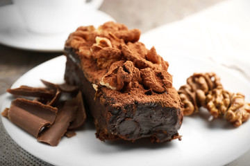 A piece of chocolate cake with walnut on the table, close-up