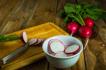 Slices of fresh radish on the used chopping board, copy space