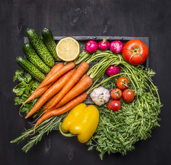 Colorful various of organic farm vegetables in a wooden box on wooden rustic background top view close up