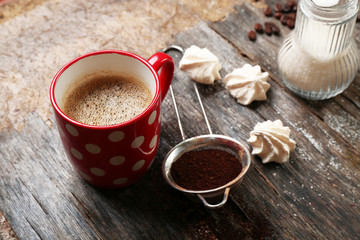 Cup of coffee with sweets on wooden background