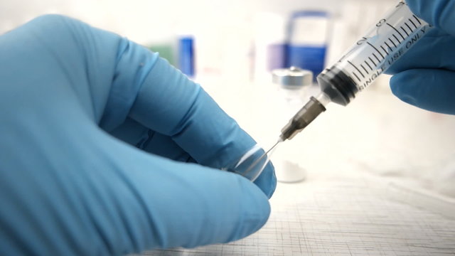 Female doctorFemale doctor carefully preparing an injection