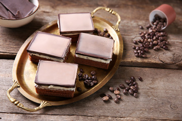 Delicious chocolate brownies on tray, on wooden background