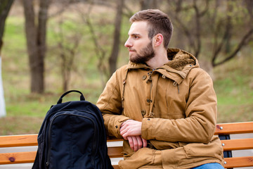 Pensive man sitting on the bench outdoors