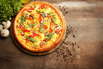 Delicious pizza with salad and Champignon on wooden background