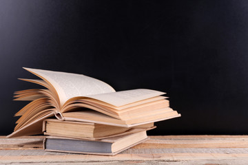 Stack of books on wooden table,  black background