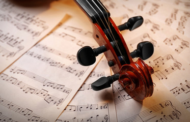 Naklejka premium Violin neck on music papers background