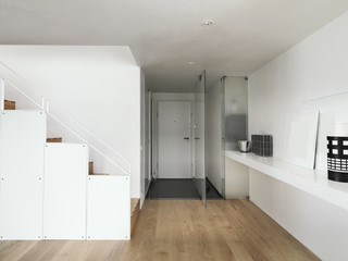 interior view of an entrance of apartment with wood floor and staircase