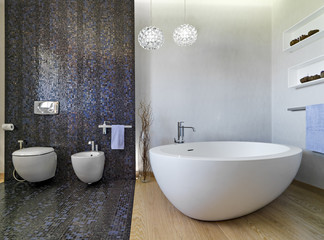 interior view of a modern bathroom with wood floor  in foreground the bathtub and whose walls are...
