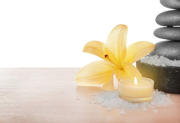 Spa stones with lily, candle and sea salt, isolated on white