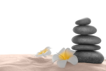 Few spa stones with plumeria on sand, isolated on white