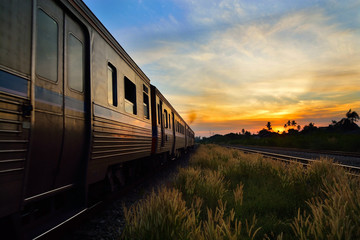 Obraz premium Train Passing by over Rural Railway in the Morning or at Dawn wi