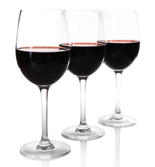 Three glasses of red wine on light background